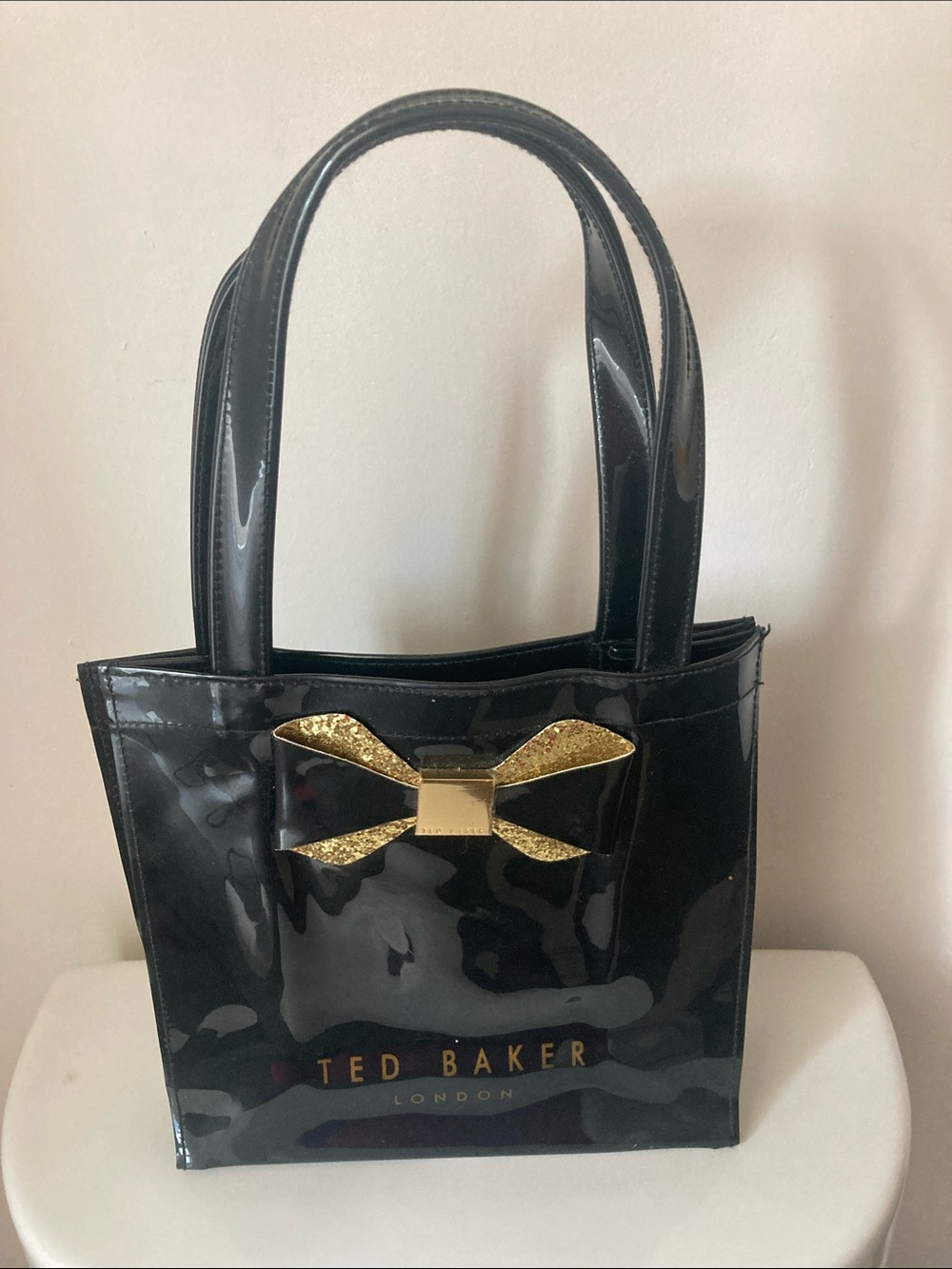 Ted Baker Black Patent Tote with Gold Bow Accent., small stitch flaw. Bottom